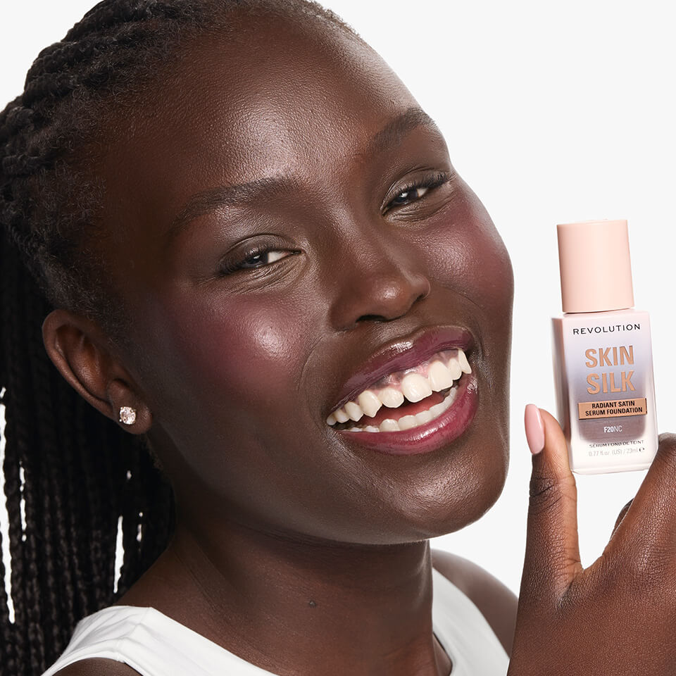 Model wearing and holding the Revolution Skin Silk Serum foundation